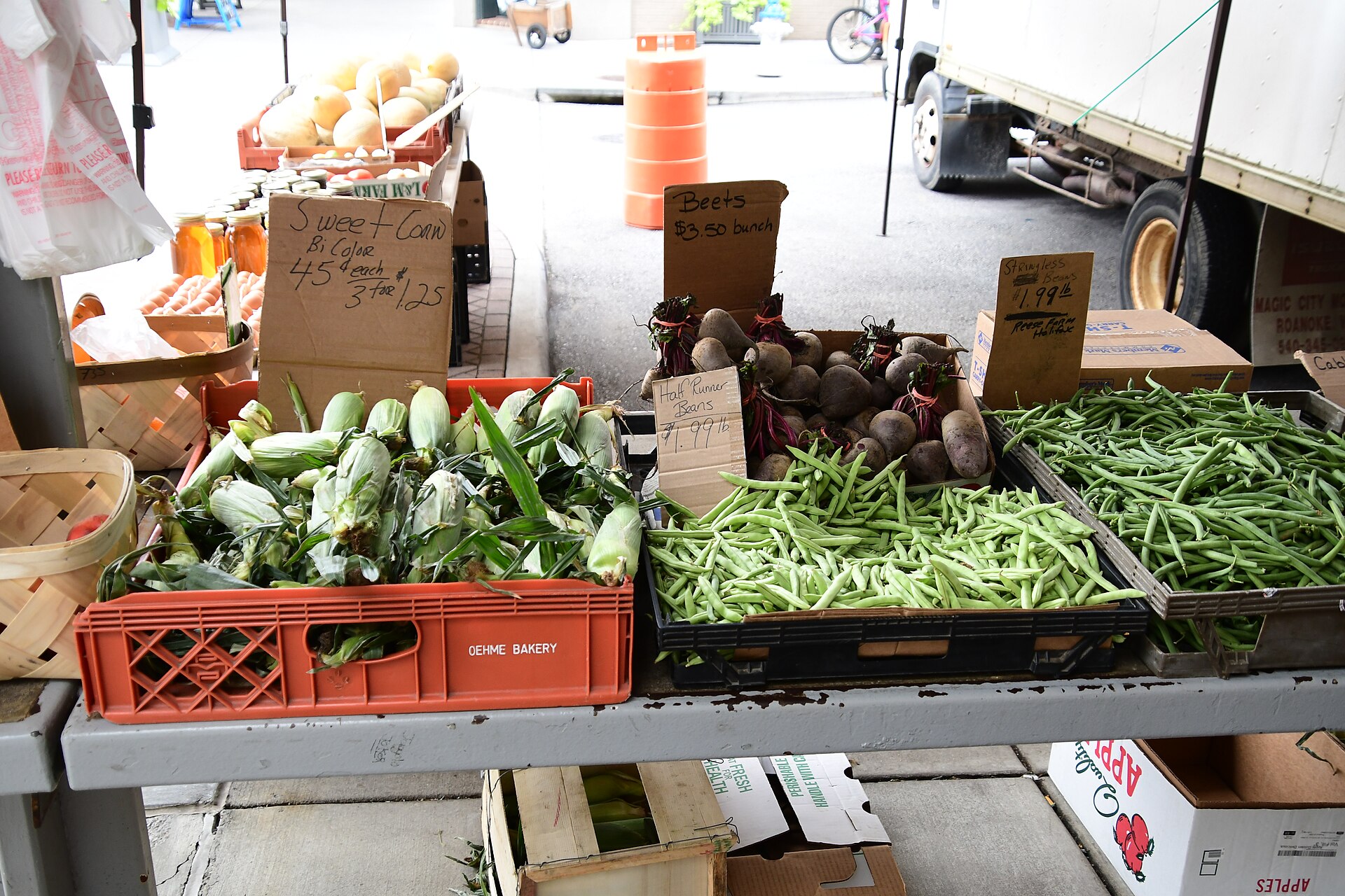 Roanoke City Farmers Market stalls — foot traffic and wait moments in downtown Roanoke, Virginia